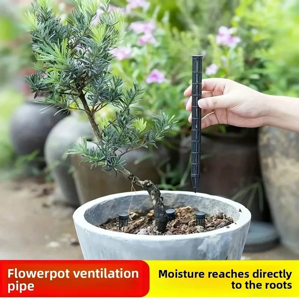 A hand holds a black plant aeration tube inserted into the soil of a white flowerpot for potted plant ventilation.