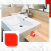 A hand is using a red silicone caulking tool on a white bathroom sink and faucet area.