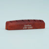 A wooden guitar bone bridge saddle with the inscription Guyker ATR-4369
