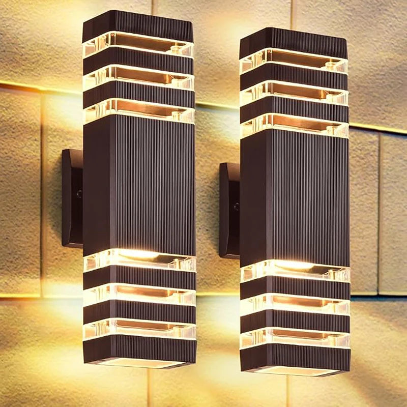 Ein Paar moderne schwarze LED-Wandleuchten mit warmweißem Licht, montiert an einer strukturierten Wand.