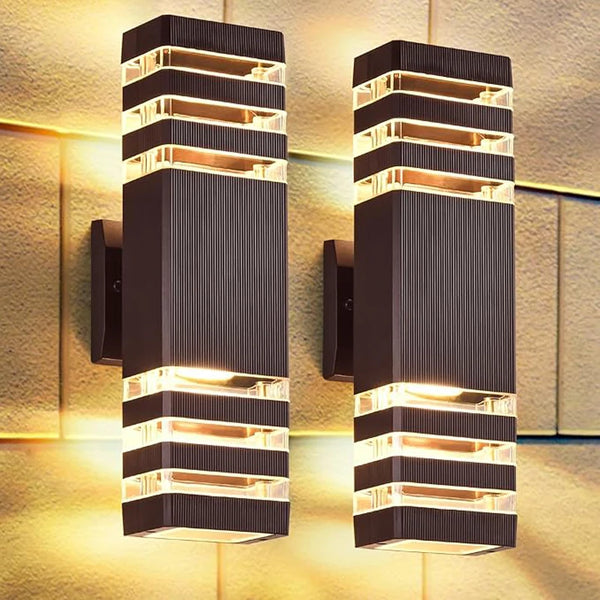 A pair of modern black LED wall sconces with warm white light mounted on a textured wall.