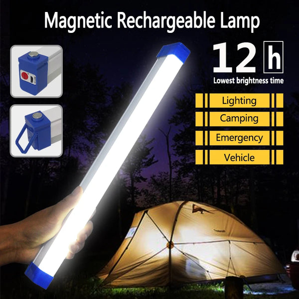 Eine Hand hält eine helle weiße magnetische wiederaufladbare Lampe, die eine dunkle Außenansicht in der Nähe einer Zelt beleu