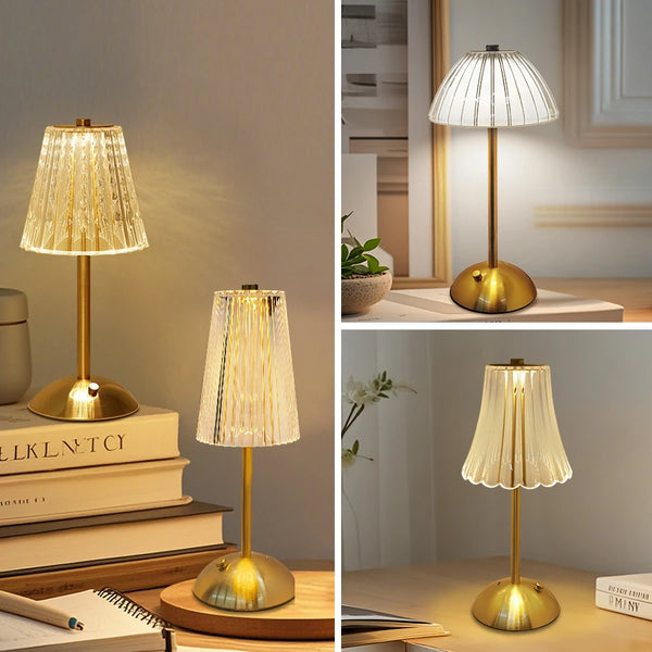 A gold-toned desktop reading lamp with a textured glass shade illuminates a stack of books.