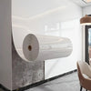 Rouleau de vinyle effet marbre autocollant mural monté sur un mur blanc dans un intérieur moderne.