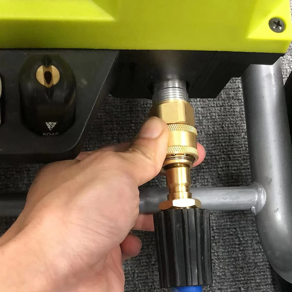 Eine Hand hält einen Messing-Schnellverschlussadapter für eine Druckwaschmaschine, die Verbindungspunkte zeigt.