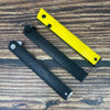A yellow foldable utility knife with a black handle resting on a wooden surface.