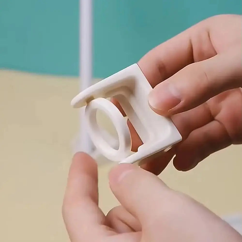 A hand holds a white 360° rotating adhesive curtain rod bracket, showing its circular and rectangular components.
