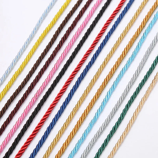 A collection of thin, braided polyester craft cords in various colors including black, pink, blue, gold, and gray.