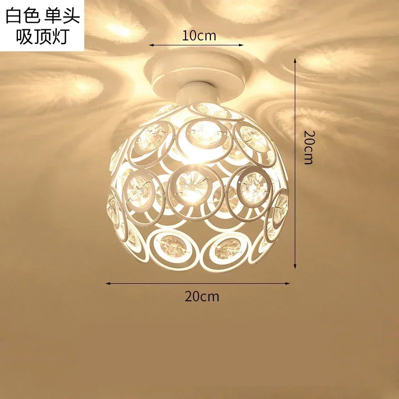 White crystal chandelier lamp with a round shade and decorative cutouts, shown hanging from the ceiling.