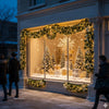 A display of gold and white Christmas decor featuring LED rattan garlands and decorated trees in a storefront window.