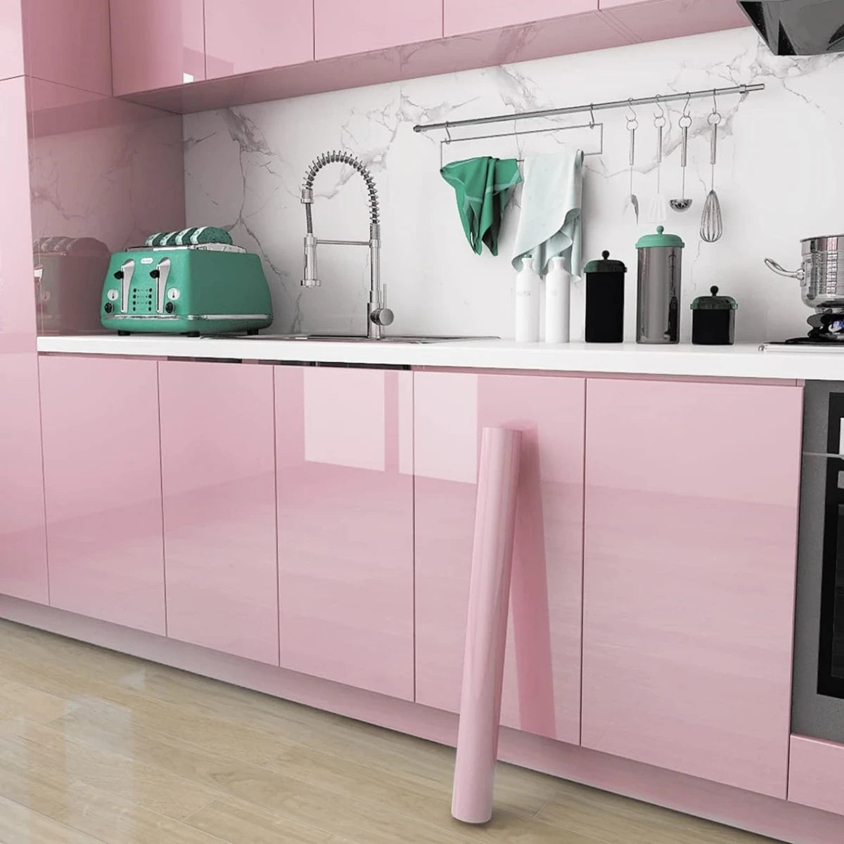 A kitchen cabinet featuring glossy pink marble contact paper and a sink area with stainless steel fixtures.