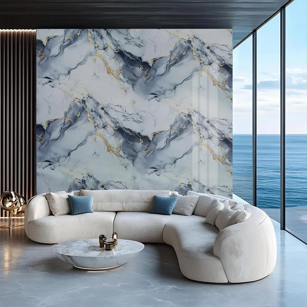 A modern living room featuring a light beige sofa against a marble wall with gray and gold veining.