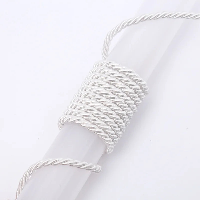 A white braided polyester craft cord is wrapped around a white cylindrical object.