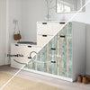 Weißer Schrank mit Holzmaserung und Klebefolie-Türen in Blau- und Grautönen.