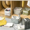 A collection of foldable linen storage baskets in various patterns and colors, including yellow, gray, and black, displayed o