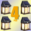 Four solar motion sensor outdoor wall lights with solar panels illuminating a dark metal fixture.