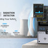 A professional nuclear radiation detector device with a digital display and battery is shown on a surface.