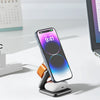 A foldable magnetic wireless charging station featuring a smartphone and earbuds on a white desk.