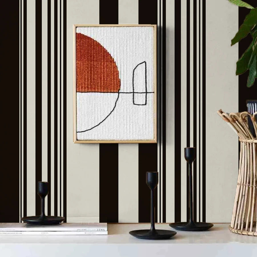 A framed artwork featuring a geometric design in white and burnt orange on a textured background.