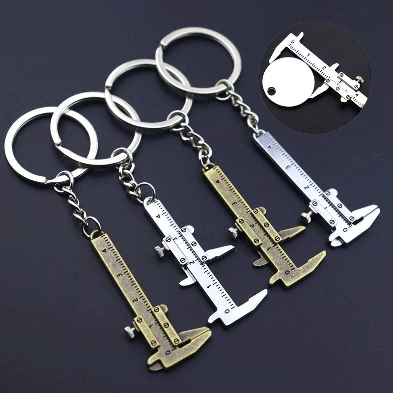 A set of precision metal jewelry measuring rulers and calipers attached to a keychain.