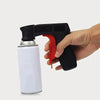 A hand holds a black spray paint handle with a red grip and a white bottle.