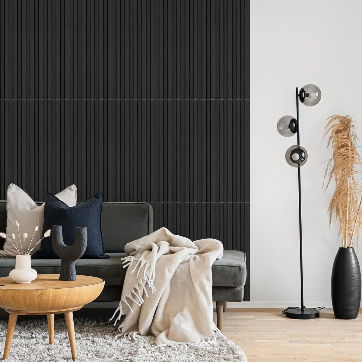 A modern living room featuring a dark gray sofa, wooden coffee table, and a tall black floor lamp with spherical lights.