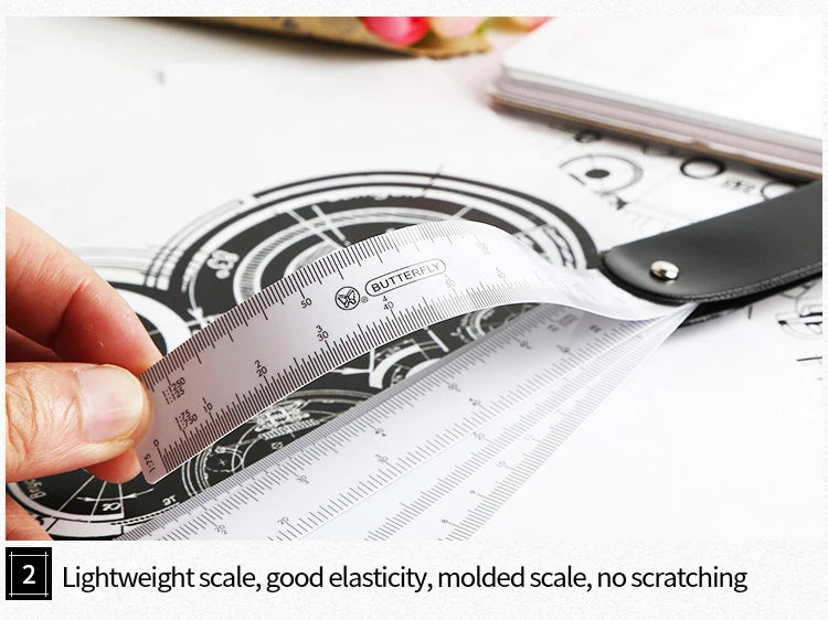 A hand holds a white precision triangular scale ruler against a dark background with drafting paper.