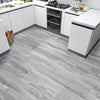 Light gray wood grain peel and stick floor tiles installed in a modern kitchen setting.