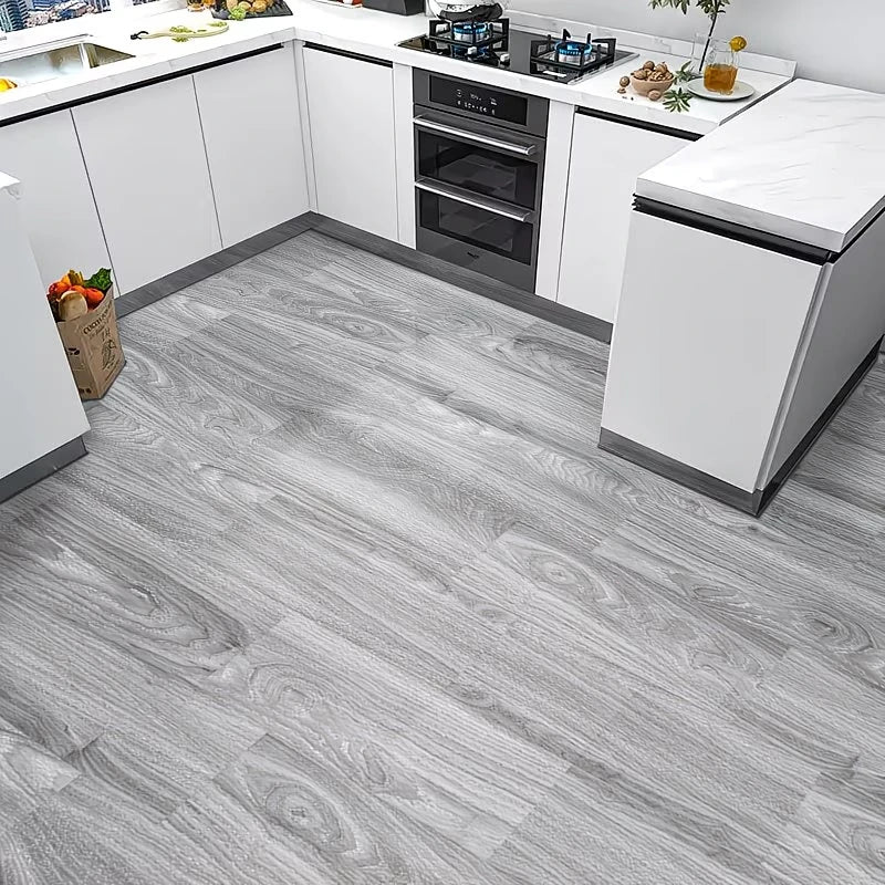 Light gray wood grain peel and stick floor tiles installed in a modern kitchen setting.