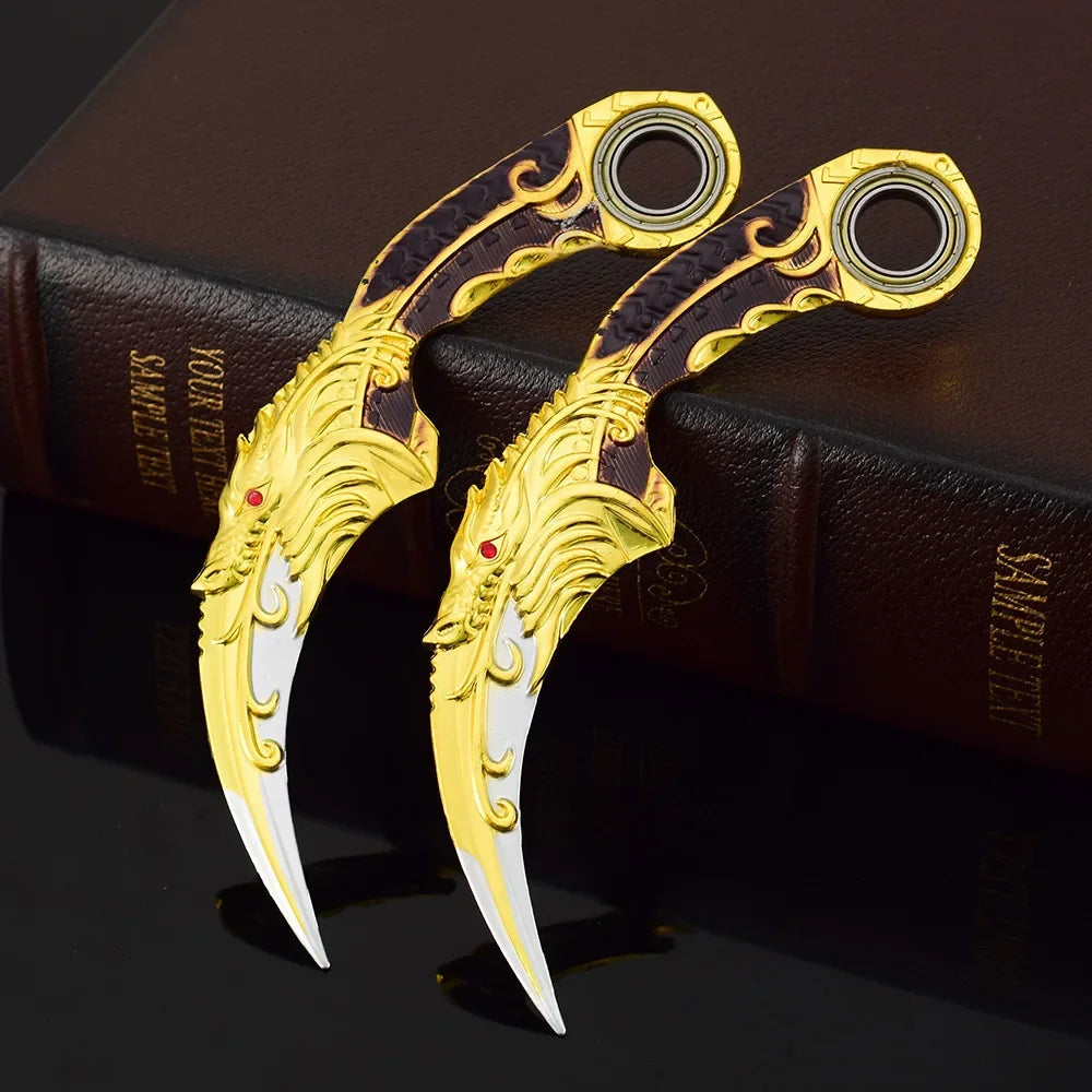 Ein Paar verziertes Gold- und schwarzes Drachenklafwaffe-Modellmesser auf einem dunkelbraunen Buch.