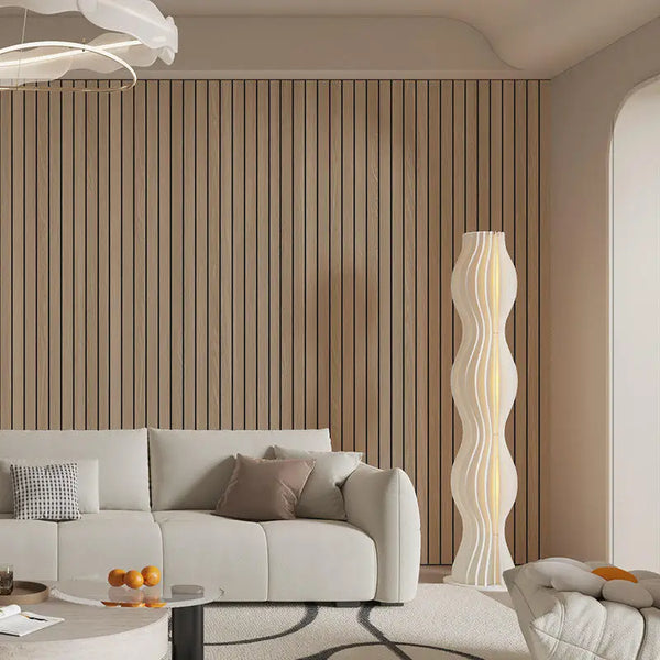 Modernes Wohnzimmer mit Holzlamellenwand, weißer Couch und hoher, gewellter Dekorationsleuchte.
