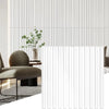 White fluted PVC wall panels used as interior decor in a modern room with a chair and plant.