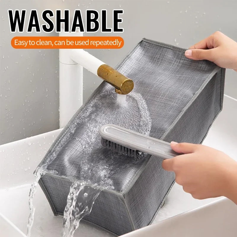 A gray fabric storage organizer box is being washed under running water.
