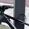 A close-up of a black bike cable lock attached to a bicycle frame, next to a vertical metal post.