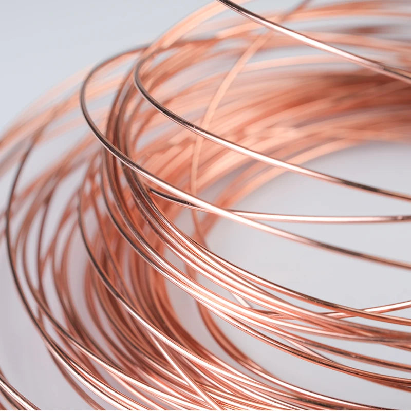 A coil of reddish-copper bare wire is shown in a close-up, spiraling across the frame.