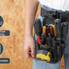 A person is wearing a black tool pouch with a belt clip attached to their jeans, highlighting its features.