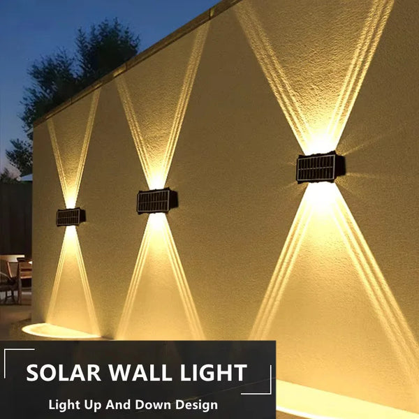 A solar wall light illuminates a textured wall with a light up and down design.