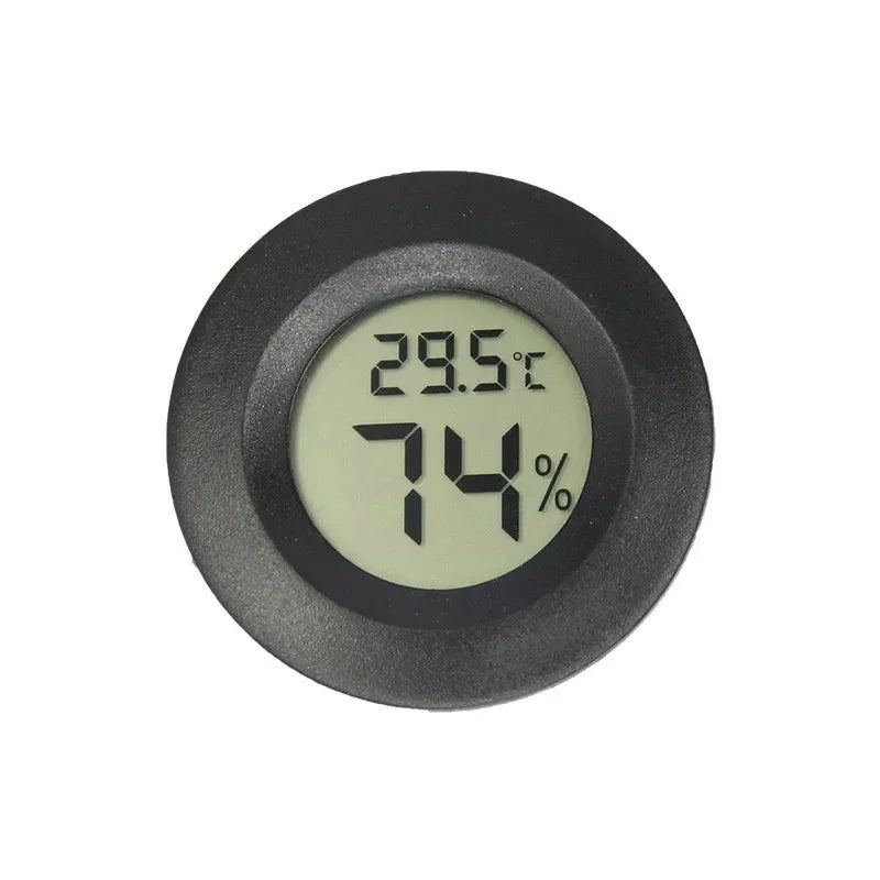 A round, black digital indoor humidity and temperature meter displaying 29.5°C and 74%.