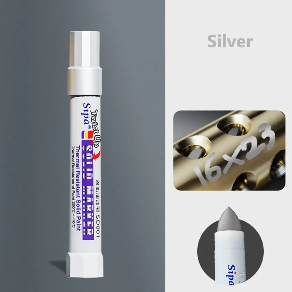 Silver solid paint marker pen with a white body and purple tip shown next to a gold metallic surface.