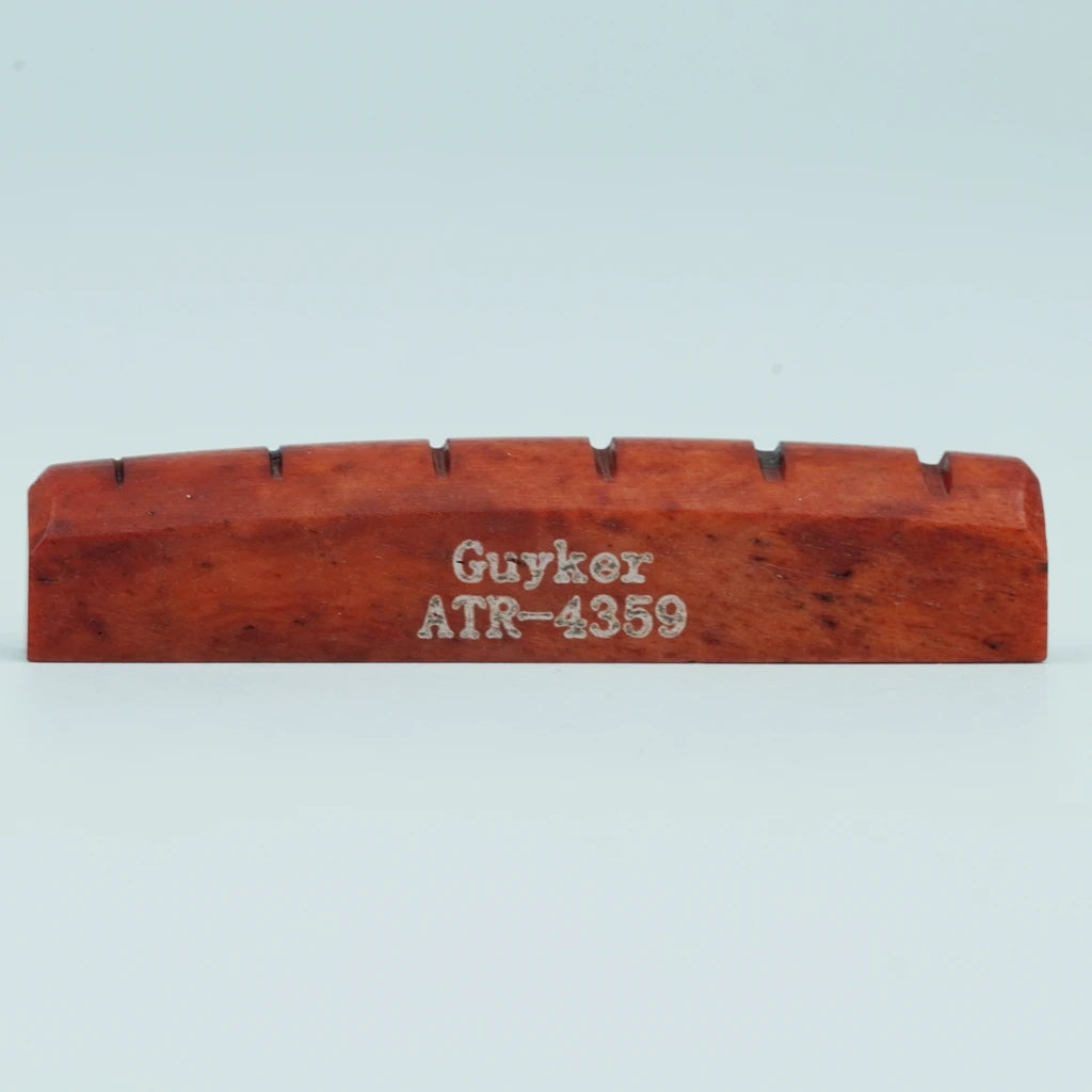 A wooden acoustic guitar bone bridge saddle with the name Guyker ATR-4359 engraved on it.
