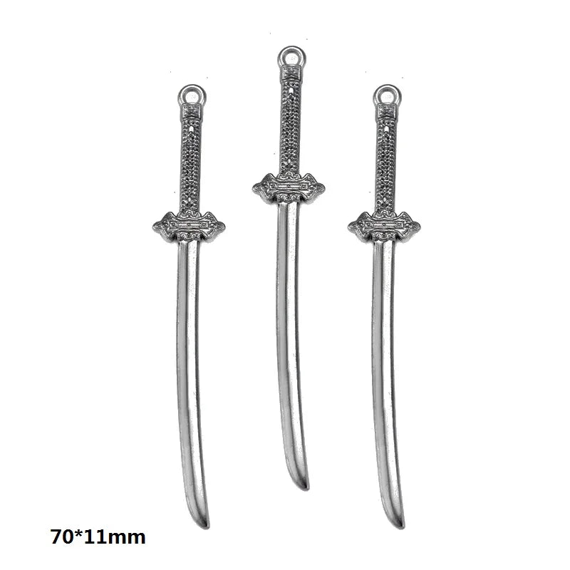Three silver-colored alloy charms or small swords with decorative hilts and blades.