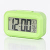 Reloj digital de alarma LED verde lima con pantalla rectangular mostrando las 12:00 y información de hora/fecha.