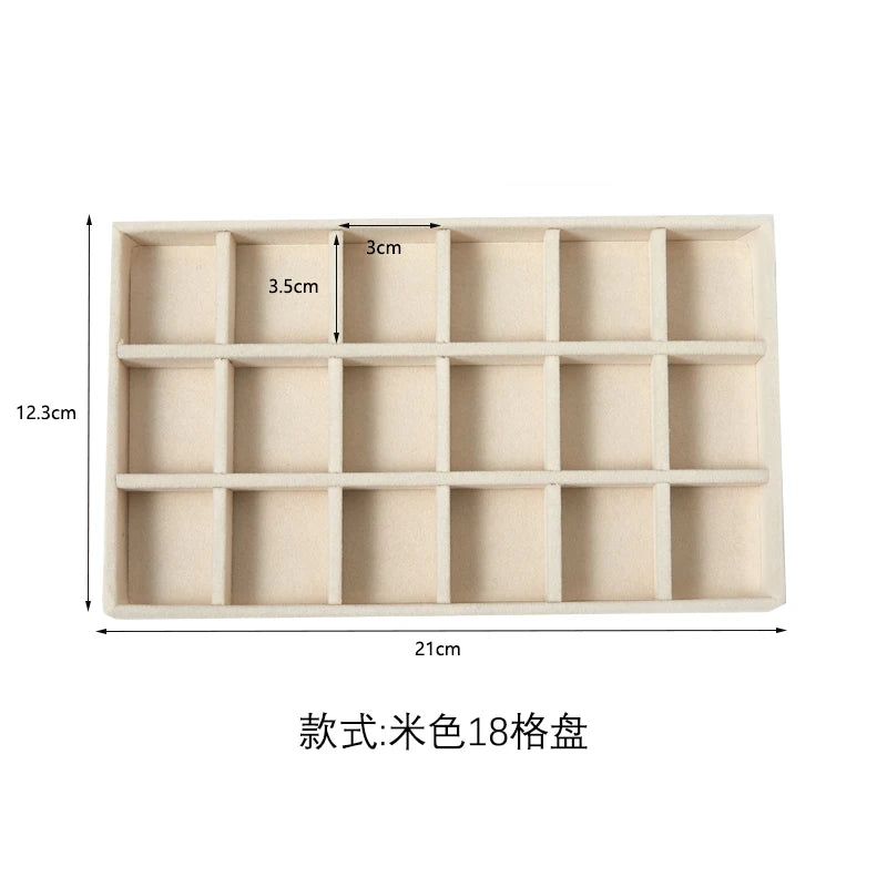A rectangular beige jewelry storage tray with 18 compartments for plush velvet jewelry.
