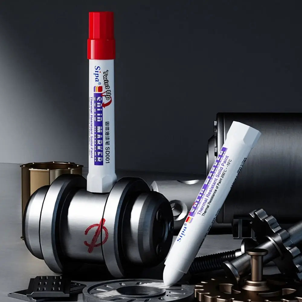 A white solid paint marker pen with a red cap is shown next to a silver paint cylinder and various tools.