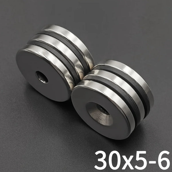 A close-up view of precision disc countersunk hole magnets with a 30x5mm size.