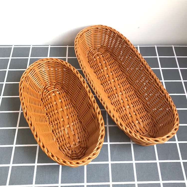 A pair of natural rattan woven serving baskets resting on a gray checkered surface.