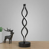 A black and white spiral desk lamp with a deer silhouette base.