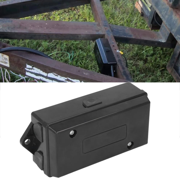 A black waterproof distribution block for power connectors is shown against a background of metal framing and grass.