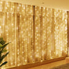 Goldener durchscheinender Vorhangstoff, beleuchtet von warmweißen LED-Lichterketten für Home-Dekoration
