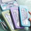 A set of purple and teal geometry tools including a compass, ruler, and protractor displayed in a light green case.